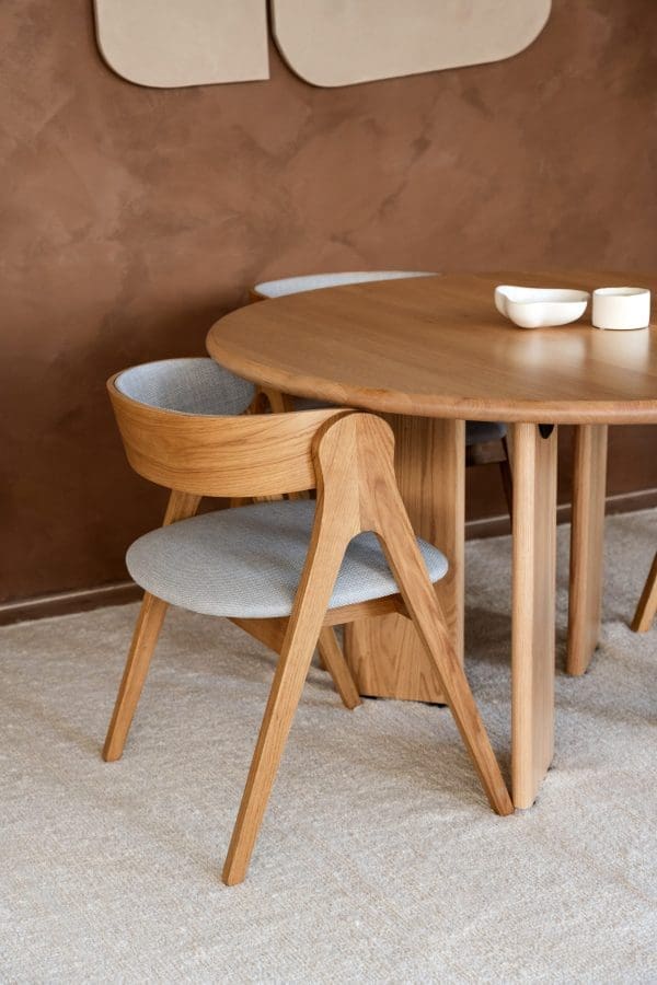 Japandi eetkamerstoel Anna met naturel houten frame en lichtblauwe stof, passend in een rustig, warm en minimalistisch Japandi interieur.